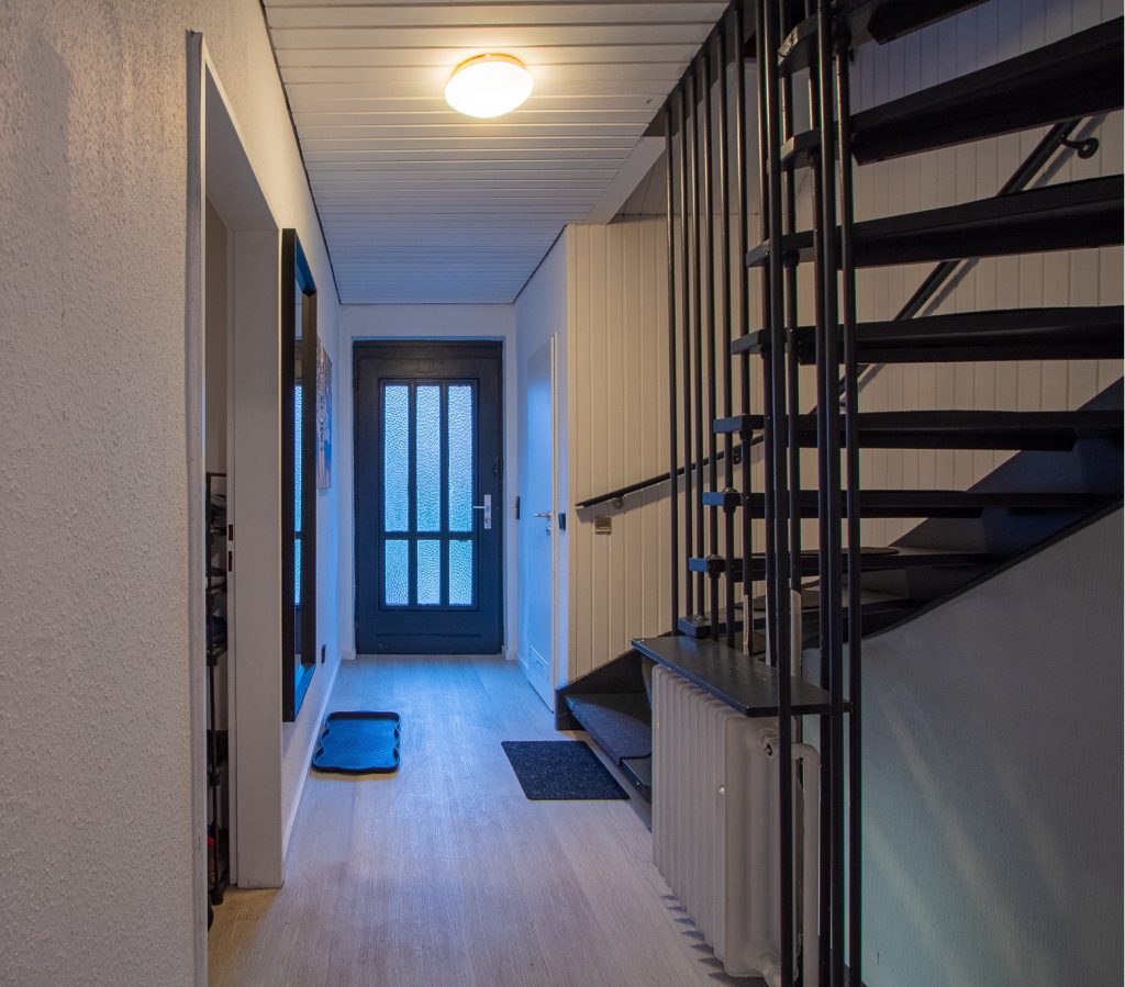 Heller Flur mit Treppe und Tür