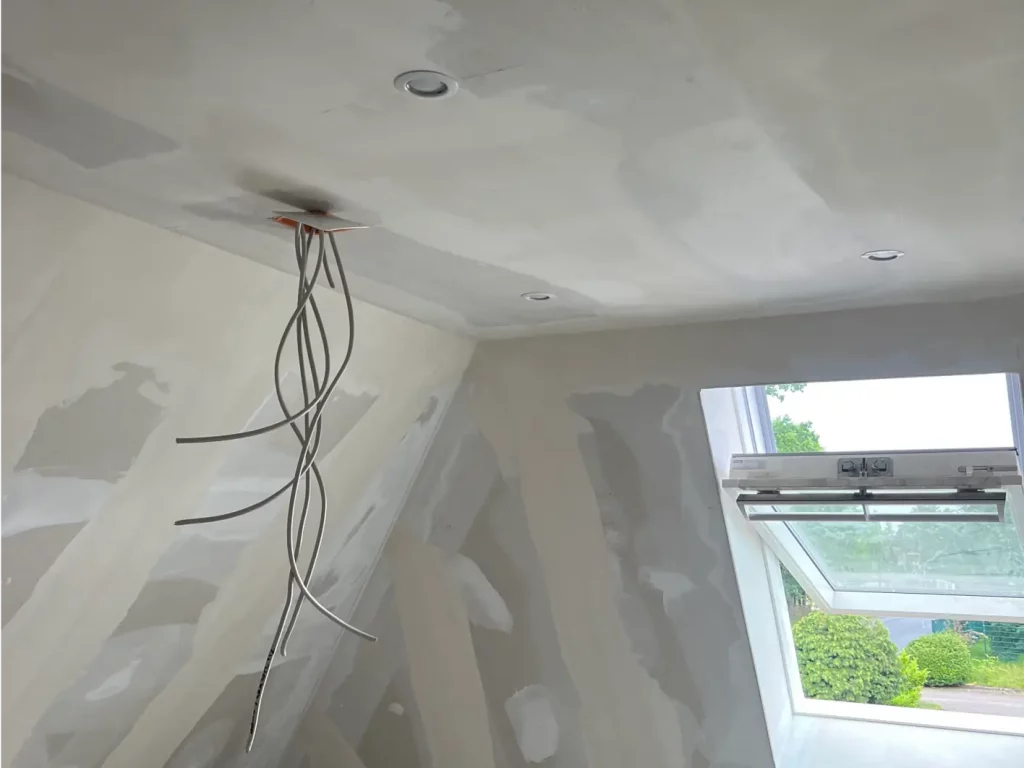 Unfertige Decke mit Kabeln und Fenster trockenbau